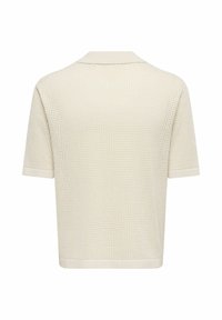 Polo en maille crème à manches courtes avec texture gaufrée, col plat et ourlet droit, vu de dos.