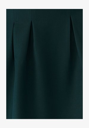Donkergroene geplooide rok van gestructureerde stof, met scherpe plooien en nette stiksels, zonder zichtbare hardware of versieringen.