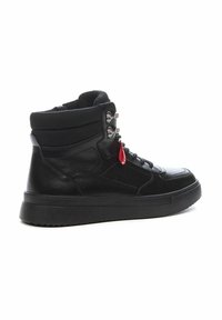 Zapatillas negras de caña alta hechas de cuero y textil; cuentan con cierre de cordones, acentos metálicos y una suela texturizada con un detalle de etiqueta roja.