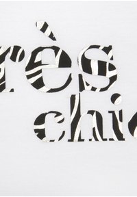 Weißer Baumwollstoff mit metallisch schwarzen und weißen zebraartigen Schriftzügen, die "très chic" in einem fetten, grafischen Design spellten.