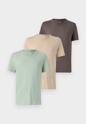 Tre v-hals t-shirts i afdæmpede farver: grøn, beige og brun. Korte ærmer, blødt stof og et lille logo på brystet af hver.