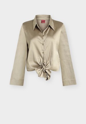 Chemise longue en satin beige à boutons avec col pointu et détail nœud à l'avant, signée Hugo.