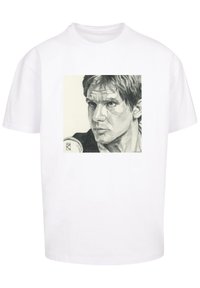Hvid bomulds t-shirt med en gråskala illustration af et ansigt i et firkantet design på forsiden. Korte ærmer og rund halsudskæring.