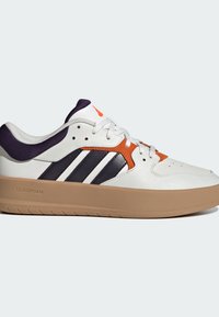 Baskets blanches avec des accents bleu marine et orange, dotées d'une tige en cuir lisse, d'une semelle en caoutchouc et d'un design à trois bandes sur le côté.