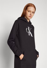 Calvin Klein Jeans HOODIE DRESS GLOSSY MONOLOGO CENTER CHEST - Day dress -  black - Zalando.co.uk