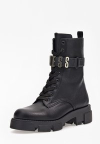 Bottines en cuir noir avec surface texturée, design à lacets, semelle épaisse et bande métallique avec le détail "ESS".