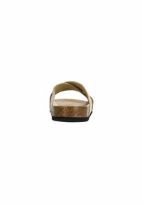 Light beige sandals with two overlapping straps, cork footbed, and a black rubber sole, viewed from the back. Flat design with minimal detailing.