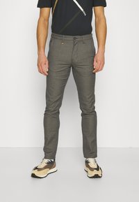 Grå skräddarsydda byxor med en slät textur, slim fit, subtilt mönster och knappstängning; tillsammans med en svart grafisk t-shirt och sneakers.