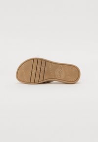 Semelle de chaussure en caoutchouc brun clair avec un motif texturé imitant le bois et des rainures horizontales ; présente le nom de la marque imprimé "Gabor" sur sa surface.