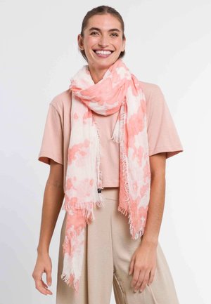 Lightweight scarf in white with soft coral watercolor splashes, featuring fringed edges and a sheer texture, worn draped around the neck.