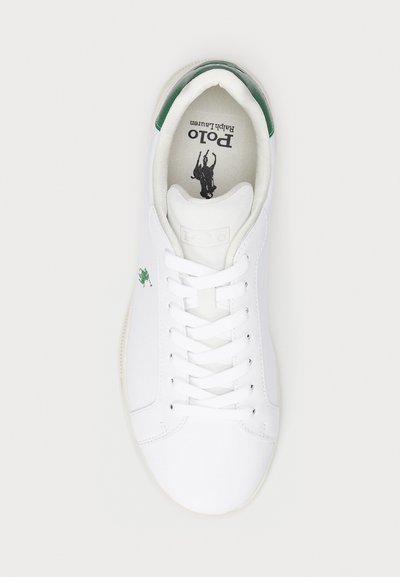 Vita lädersneakers med gröna hälaccenter. Har en rund tå, platt snörningsdesign och en svart logotryck på innersulan.