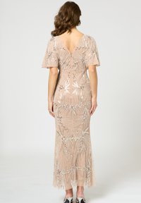 Besetztes, hautfarbenes Kleid mit V-Ausschnitt und kurzen Flatterärmeln. Verfügt über filigrane Blumenmuster in Silber und eine fließende Silhouette.