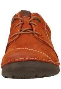 Scarpa in pelle arancione con punta tondeggiante, design con lacci, cuciture bianche a contrasto e suola in gomma testurizzata. Accentuata da un patch con logo marrone.