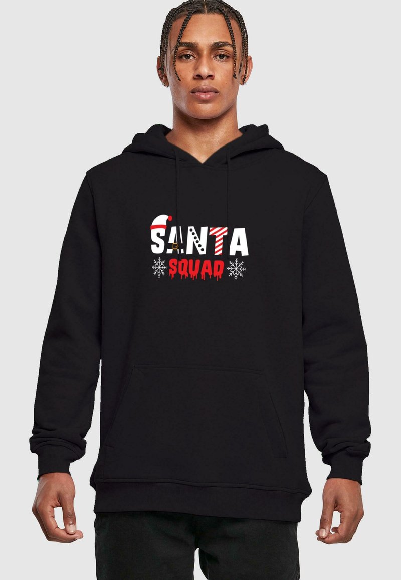 Černá mikina s kapucí s nápisem "SANTA SQUAD" v červených, bílých a vzorovaných písmenech. Obsahuje přední kapsu a stahovací šňůrku na kapuci.