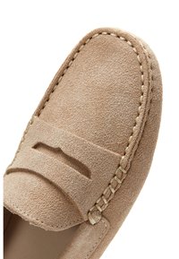 Light brown suede loafer with detailed topstitching and a penny strap across the vamp, shown from a close-up angled view.