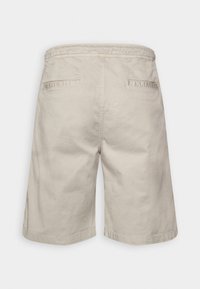 Beige knee-length shorts with two back welt pockets and an elastic waistband, shown from the rear.