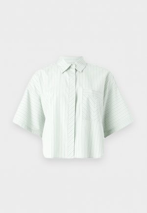 Hvit kortermet skjorte med tynne vertikale og chevronstripe-mønstre, knappelukking foran og en brystlomme på ensfarget bakgrunn.