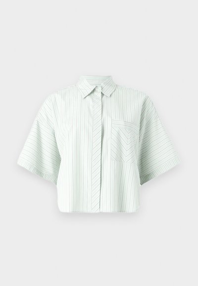 Λευκό πουκάμισο με κοντά μανίκια, λεπτές κάθετες και ζιγκ-ζαγκ ρίγες, με κούμπωμα μπροστά και τσέπη στο στήθος, σε μονόχρωμο φόντο.