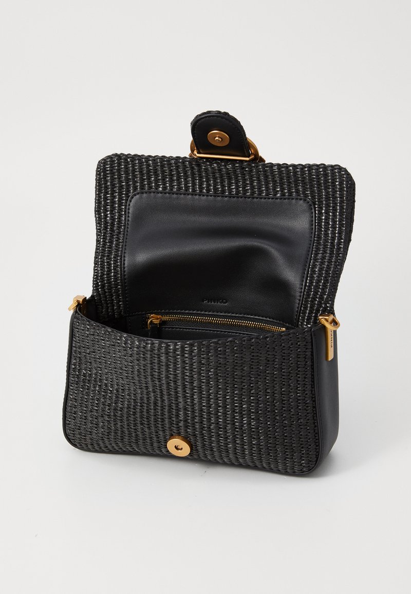 Zwarte geweven crossbodytas met gouden sluiting en rits, geopend om de gladde zwarte lederen binnenzak en magnetische klepsluiting te tonen.
