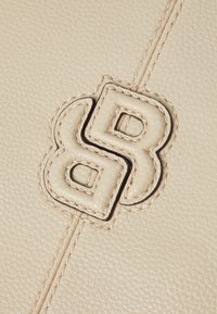 Materiale in pelle beige con una texture a piccoli ciottoli. Presenta un logo in rilievo ben visibile con cuciture scure lungo la cucitura centrale.