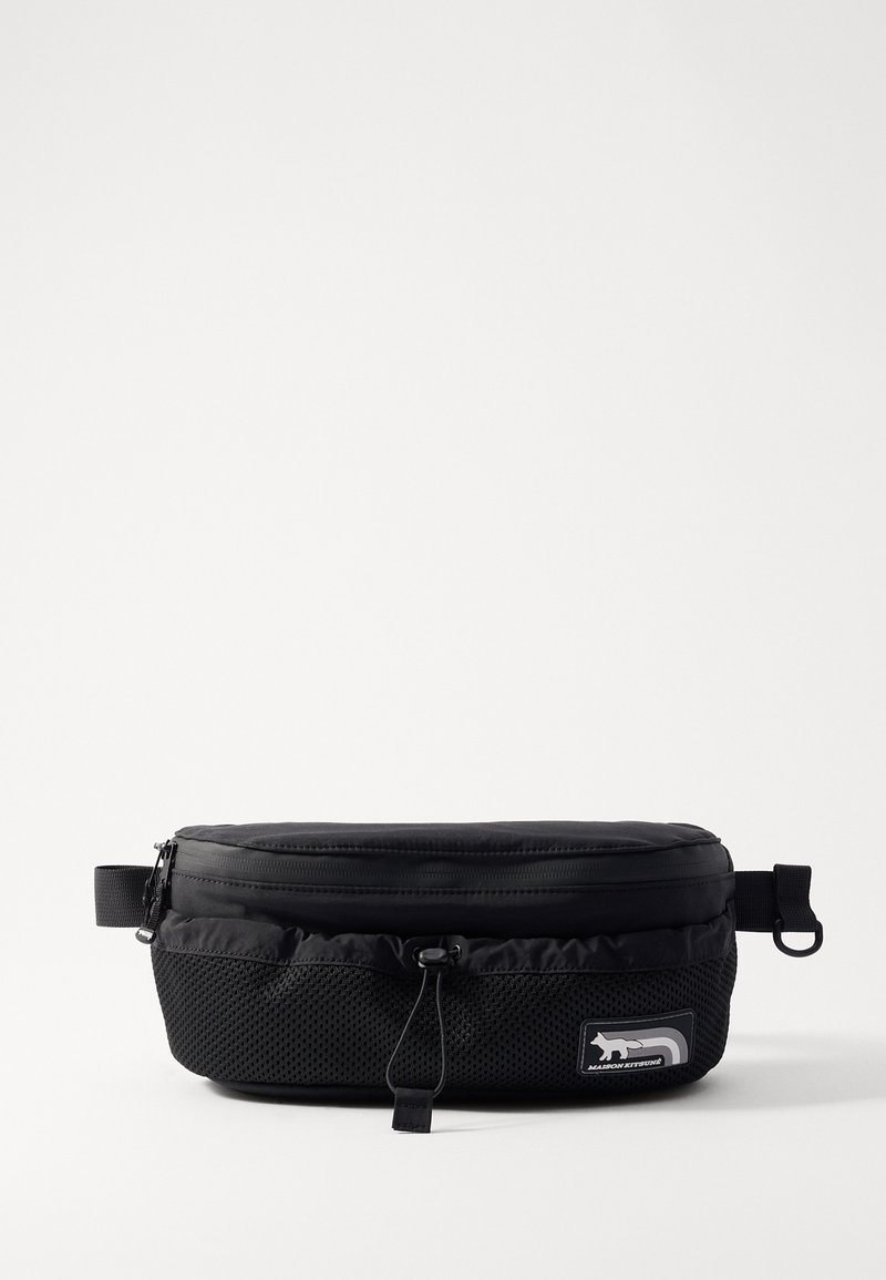 Sac banane noir, fabriqué en tissu durable, comporte une fermeture éclair, un panneau en mesh, une sangle réglable et une étiquette logo à l'avant.