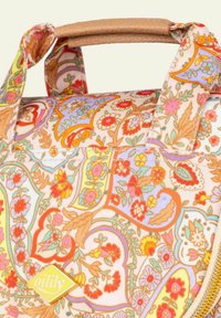 Bolso de tela resistente con un estampado floral multicolor. Tiene un asa en color arena, cremallera y una etiqueta de logo amarilla en la parte delantera.