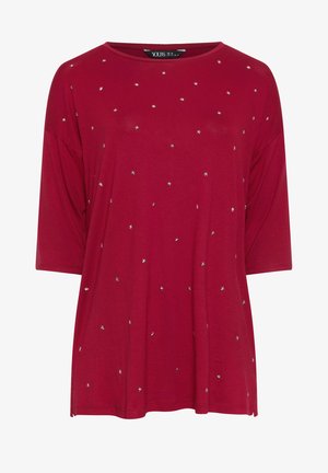 Burgundy lyhythihainen paita, jossa on rento istuvuus ja hopeisia tähden koristeluita hajallaan etupinnalla. Silkkinen kangas, pyöreä pääntie.