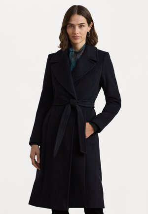 Manteau en laine noir avec un col cranté, des manches longues, une taille cintrée et des poches latérales. Texture lisse et design ajusté.