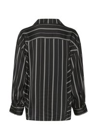 Majica s črnimi in belimi črtami, ki ima ovratnik, dolge rokave z gumbnimi manšetami in ohlapen kroj. Gladka tekstura in vodoravni zadnji del.