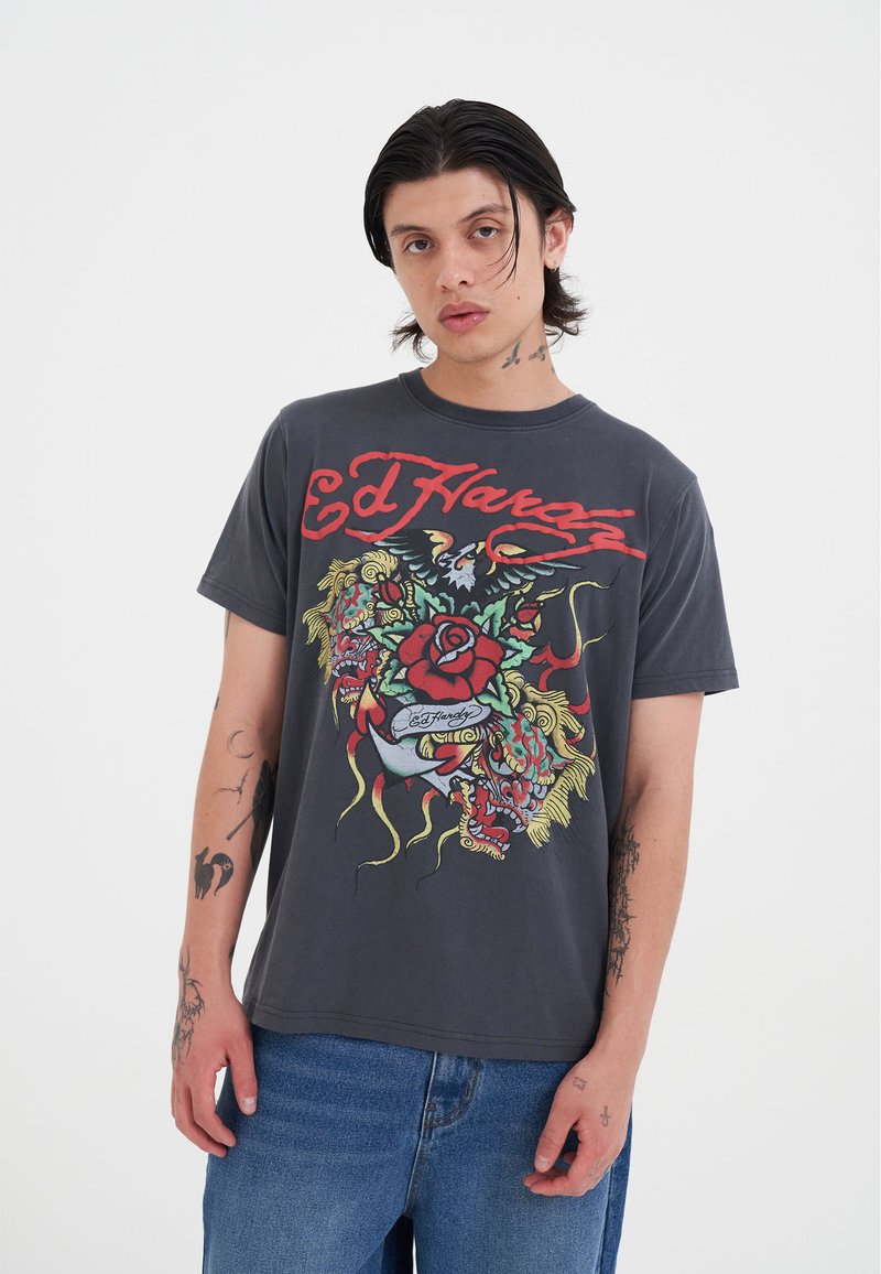 Camiseta de algodón gris con un diseño gráfico colorido que presenta motivos florales y de dragón. Mangas cortas y un ajuste relajado.