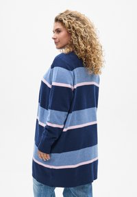 Gilet tricoté avec de larges rayures horizontales en marine, bleu clair et rose. Manches longues, coupe décontractée et ourlet côtelé.