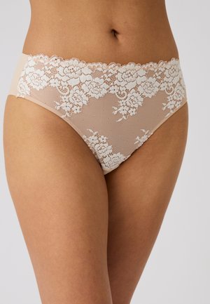 Beige kanten ondergoed met bloemmotief gedragen op de taille, met zicht op de onderkant van de romp en de bovenste dijen tegen een effen achtergrond.