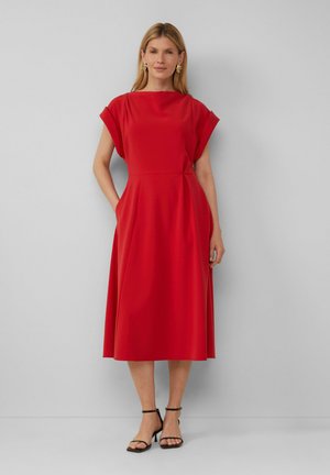 Robe rouge avec des manches courtes drapées ; corsage ajusté et jupe ample descendant jusqu'au mollet ; tissu lisse ; dotée de poches latérales et de détails de couture subtils.