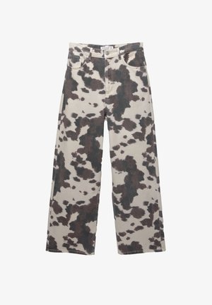 Jeans évasés de couleur beige avec un motif imprimé vache marron. Présentent une fermeture à bouton et un design à cinq poches. Fabriqués en denim.