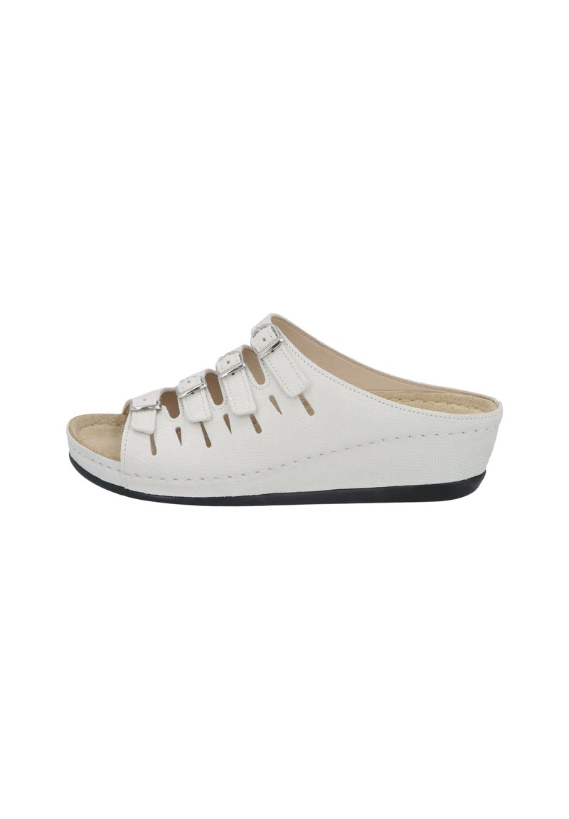 White wedge slide sandals made of textured material, featuring cut-out details and three adjustable straps. Soft, cushioned footbed and black sole.