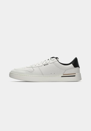 Witte lage sneaker met zwarte hiel, vetersluiting, subtiele perforaties en het "BOSS" logo aan de zijkant, getoond vanuit het zijprofiel.