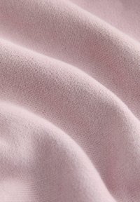 Light pink fabric with a soft, textured finish. The material shows gentle folds, suggesting a smooth and lightweight weave.