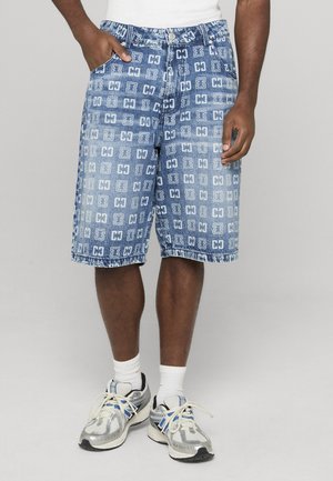 Denim shorts met een blauw patroonontwerp met herhalende logo's. Gefranjerde zoom, vijf zakken en een knoopsluiting. Gecombineerd met sneakers.
