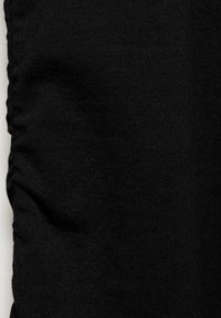 Tissu noir avec un aspect texturé, présentant des détails froncés sur un côté, créant une subtilité de dimension et de profondeur. Surface lisse.
