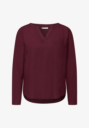 Burgundská halenka s dlouhým rukávem a véčkovým výstřihem, vyrobená z hladkého materiálu; má zaoblený lem a boční rozparky pro snadný pohyb.