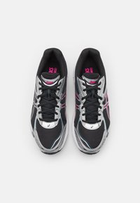 Black and silver athletic shoes with pink accents, featuring a mesh upper, laces, and a cushioned sole. Reflective detailing across the design.
