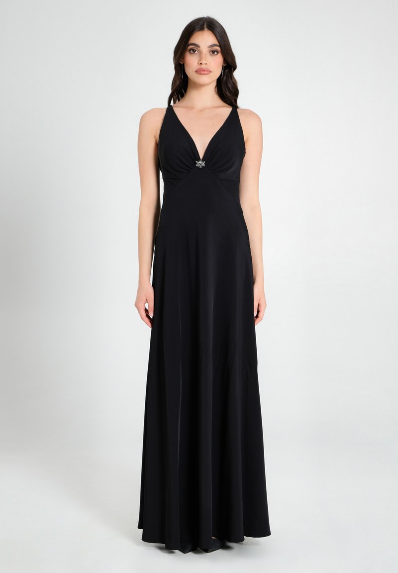 Langes schwarzes Kleid mit tiefem V-Ausschnitt, gerafftem Mieder und einem mit Juwelen besetzten Akzent in der Mitte. Glatter Stoff, fließende Silhouette und ärmelloses Design.