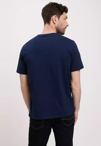 Granatowa koszulka z krótkim rękawem z mieszanki bawełny o regularnym kroju; gładka tekstura; okrągły dekolt; brak widocznych metek lub wzorów.