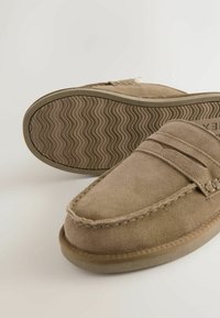 Hnedé semišové mokasíny s okrúhlou špičkou, dvojitým pruhom cez prednú časť a textúrovanou gumovou podrážkou s vlnkovaným vzorom.