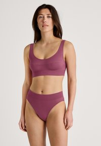Mauve-BH mit rundem Ausschnitt und breiten Trägern, kombiniert mit passenden hochgeschnittenen Slips. Glatte Textur ohne Verzierungen.
