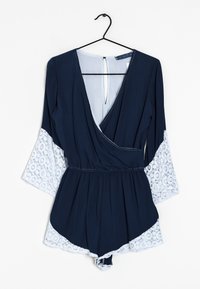 Bodycon blu navy con dettagli in pizzo sulle maniche a campana, scollatura profonda a V e vita elastica. Tessuto morbido e dettaglio a chiave sulla schiena.