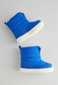 Blaue isolierte Stiefel mit einem gesteppten Design, runder Zehenpartie und weißen Gummisohlen, ausgestattet mit einer Schnur und einer Zuglasche für einfaches Anziehen.