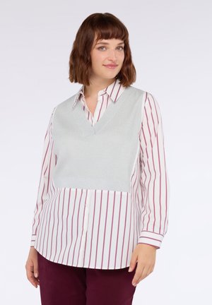 Gilet en maille gris clair avec un col en V sur une chemise blanche à rayures verticales bordeaux. La chemise a un devant boutonné et des manches longues.