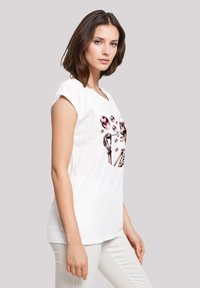 Kurzärmliges weißes T-Shirt mit einem grafischen Design von Skeletten und Blasen in verschiedenen Rosa- und Schwarztönen; lässige Passform und weicher Stoff.