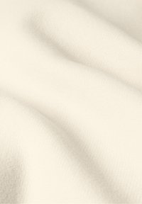 Miękka, kremowa tkanina o gładkiej, lekko teksturowanej powierzchni i subtelnym wzorze w jodełkę, ukazująca delikatne fałdy i draperie.